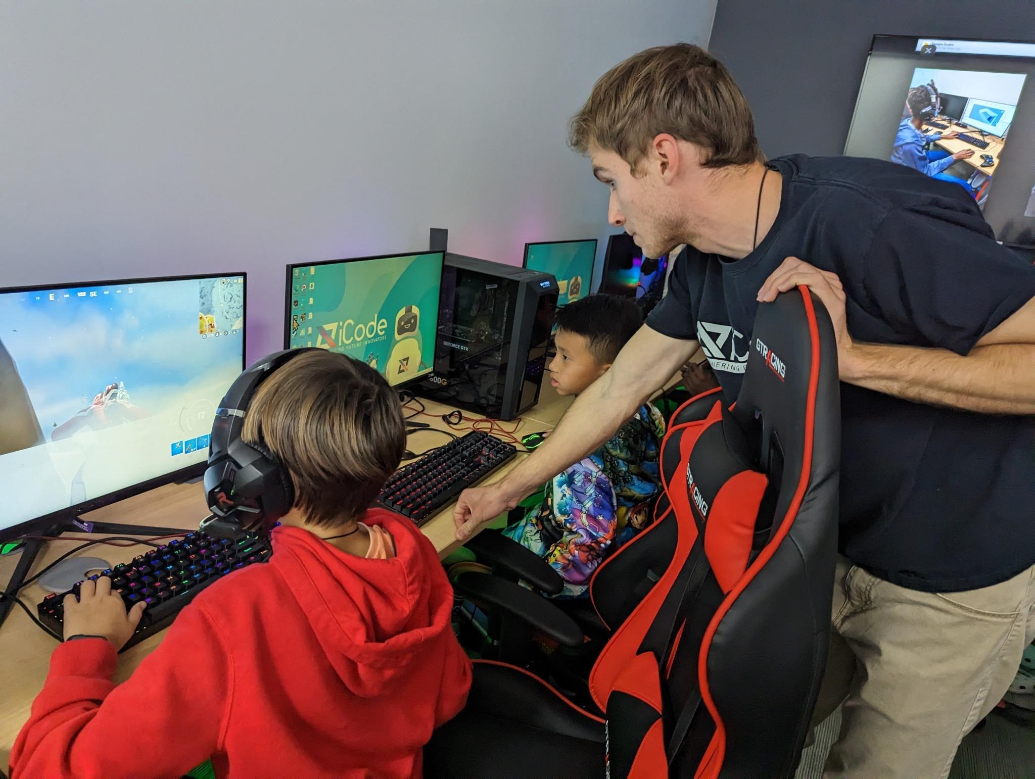 An iCode instructor helps students with a game development exercise