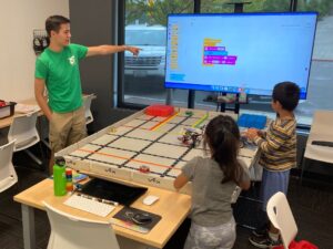 Students learning block coding in robotics summer camp
