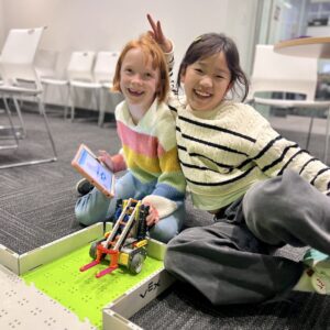 Two students posing for a phot with their robot