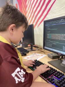 A child typing out code on a black screen