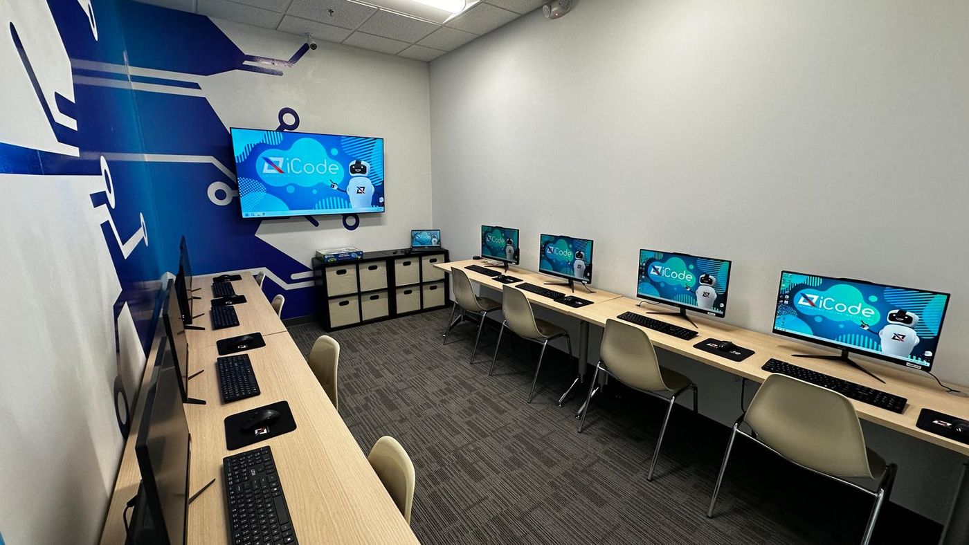 An iCode classroom with desktop computers and large monitors