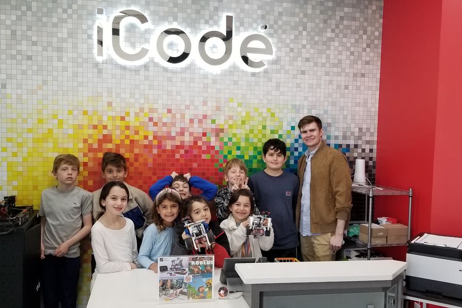 A group of iCode students and their instructor at the front desk