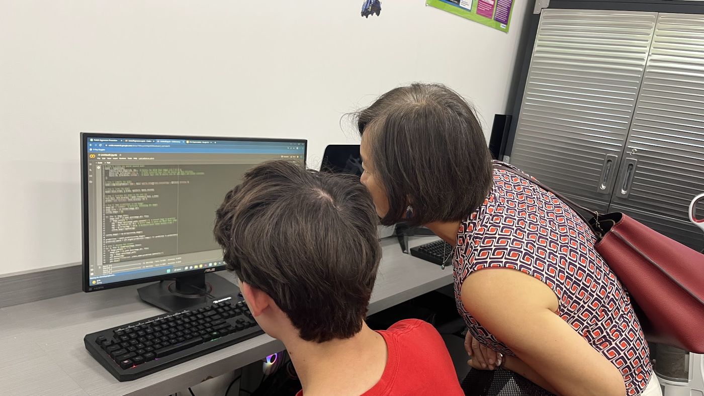 A student showing a parent the AI project they built